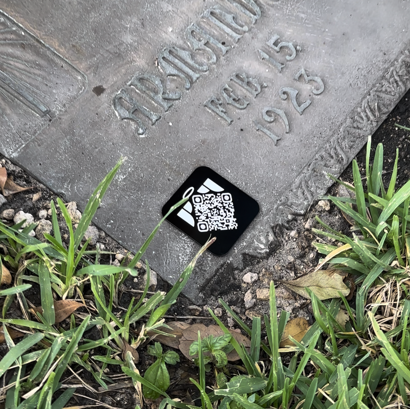 Close-up of a Memoriv QR medallion on a memorial stone